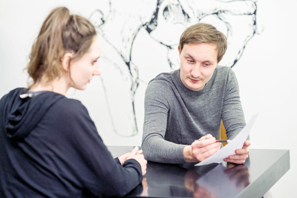 Philipp Schulzgibt macht eine Anamnese in die Physiotherapie Wien eine Patientin